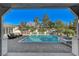 A beautiful in-ground pool with striped umbrellas, outdoor seating, and a jacuzzi are ready for fun in the sun at 6965 Tara Ave, Las Vegas, NV 89117