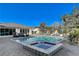 A dazzling pool and jacuzzi are complemented by black and white lounge chairs and a backyard pool house at 6965 Tara Ave, Las Vegas, NV 89117