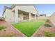 Wide view of the backyard featuring artificial turf, patio, and privacy wall at 717 Monroe Hill Pl, Henderson, NV 89011