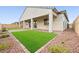 Exterior of home with a covered patio and artificial turf, accented with rocks and plants at 717 Monroe Hill Pl, Henderson, NV 89011