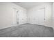 Large bedroom featuring plush carpeting, closet doors, and an adjoining bathroom entrance at 717 Monroe Hill Pl, Henderson, NV 89011