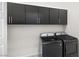 Functional laundry room with dark cabinets above a modern washer and dryer at 717 Monroe Hill Pl, Henderson, NV 89011