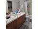 Bathroom featuring wood vanity, white countertop, and tiled floors at 7461 Enviable Ct, Las Vegas, NV 89149