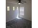 This bedroom features neutral carpet, a ceiling fan, and sunlit windows at 7461 Enviable Ct, Las Vegas, NV 89149