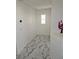 Upstairs hallway with bright natural light and marble-patterned tile flooring at 7461 Enviable Ct, Las Vegas, NV 89149