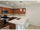 Modern kitchen with brown cabinets, stainless appliances, tile backsplash, and breakfast bar with pendant lights at 7461 Enviable Ct, Las Vegas, NV 89149