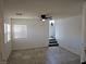 Comfortable living room with stairs leading to the upper level, a ceiling fan, and neutral paint at 7461 Enviable Ct, Las Vegas, NV 89149