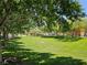 Green lawn with shade trees, ideal for picnics and leisurely activities in this community park setting at 7461 Enviable Ct, Las Vegas, NV 89149