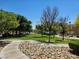 Community park area featuring winding sidewalks, lush green grass, and mature trees in a well-maintained setting at 7461 Enviable Ct, Las Vegas, NV 89149