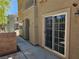 Patio area with tan stucco walls, sliding glass door, and wrought iron fencing at 7461 Enviable Ct, Las Vegas, NV 89149