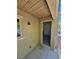 Outdoor patio space featuring a textured wall, window, and doorway with a security light at 7461 Enviable Ct, Las Vegas, NV 89149