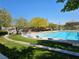 Sparkling blue community pool with comfortable lounge chairs and lush landscaping, perfect for hot summer days at 7461 Enviable Ct, Las Vegas, NV 89149