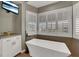 Spa-like bathroom with a modern tub and shuttered windows providing natural light at 7492 Midfield Ct, Las Vegas, NV 89120