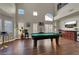 Spacious game room with a pool table, bar area, and bright, natural lighting at 7492 Midfield Ct, Las Vegas, NV 89120