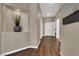 Inviting hallway with wood-look flooring and a niche wall detail with decorative items at 7492 Midfield Ct, Las Vegas, NV 89120