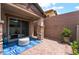 Outdoor patio area with stone pillars, stucco walls, and decorative blue outdoor rug at 778 Dainty Daffodil St, Henderson, NV 89011