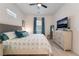 Well-lit bedroom with a comfortable bed, side tables, and dresser with mounted TV at 778 Dainty Daffodil St, Henderson, NV 89011