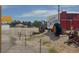 Vintage Gilcrease Orchard sign with aged tractor on graveled land near white picket fence offers outdoor charm at 7909 Citrus Meadow Ct, Las Vegas, NV 89131