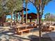 Outdoor picnic area with numerous concrete tables and benches, shaded by unique metal structures, inviting outdoor dining at 7909 Citrus Meadow Ct, Las Vegas, NV 89131