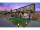 A backyard with pavers, grass, spa, pergola, and bistro lights is great for entertaining guests at 8013 Green River Knob St, Las Vegas, NV 89113