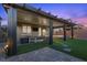 Inviting backyard patio with a pergola covering, outdoor seating, a hot tub, and beautifully landscaped artificial turf at 8013 Green River Knob St, Las Vegas, NV 89113
