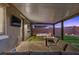 Inviting backyard patio featuring comfortable seating, a fire pit, and a soothing hot tub under a covered structure at 8013 Green River Knob St, Las Vegas, NV 89113