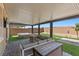 Serene backyard patio featuring a hot tub, fire pit, lounge area, and modern covered space for relaxation at 8013 Green River Knob St, Las Vegas, NV 89113