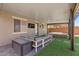 Spacious backyard patio with comfortable seating, hot tub, TV, and a relaxing fire pit under a covered structure at 8013 Green River Knob St, Las Vegas, NV 89113