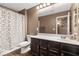 Cozy bathroom with dark wood floors, a shower with a decorative curtain and dark cabinets at 8013 Green River Knob St, Las Vegas, NV 89113