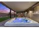 Relaxing hot tub under a covered patio with cozy lounge furniture and a charming fire pit nearby at 8013 Green River Knob St, Las Vegas, NV 89113