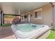 Inviting hot tub with waterfall feature set under a covered patio, perfect for outdoor relaxation and entertainment at 8013 Green River Knob St, Las Vegas, NV 89113