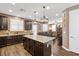 Bright, open kitchen with stone backsplash, kitchen island, and adjacent living area at 8013 Green River Knob St, Las Vegas, NV 89113