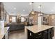Open concept kitchen featuring island with seating and views to the spacious living area at 8013 Green River Knob St, Las Vegas, NV 89113
