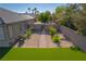 Backyard area featuring a brick path, flowers, rock ground covering, artificial grass and block wall at 8228 Fulton Ranch St, Las Vegas, NV 89131