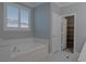 This bathroom features a tub, window with shutters, and entry into a walk-in closet at 8228 Fulton Ranch St, Las Vegas, NV 89131