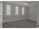 Cozy bedroom with carpet flooring, ceiling fan, and three shuttered windows at 8228 Fulton Ranch St, Las Vegas, NV 89131