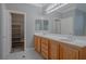 Bright main bathroom featuring dual sinks, neutral walls, and a walk-in closet at 8228 Fulton Ranch St, Las Vegas, NV 89131