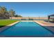 Backyard pool and tennis court with seating and grass at 8228 Fulton Ranch St, Las Vegas, NV 89131