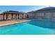 Inviting backyard pool featuring a gazebo, gravel landscaping, and a glimpse of the home's exterior at 8228 Fulton Ranch St, Las Vegas, NV 89131