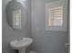 Powder room features gray walls, single sink, mirror, and shuttered window at 8228 Fulton Ranch St, Las Vegas, NV 89131