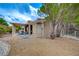 This home features a covered patio and a spacious backyard with decorative rock landscaping and mature trees at 8525 Festival Dr, Las Vegas, NV 89134