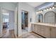 Bright bathroom featuring double sinks, arched mirrors, updated vanity, and a tiled walk-in shower at 8525 Festival Dr, Las Vegas, NV 89134