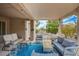 This covered patio includes comfortable lounge furniture and a blue outdoor rug to complete the space at 8525 Festival Dr, Las Vegas, NV 89134