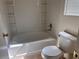 A bright bathroom featuring a tiled tub with built-in shelves and a toilet, all in white at 8688 Tomnitz Ave # 101, Las Vegas, NV 89178