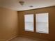 A light-filled bedroom with neutral walls featuring two windows with white blinds at 8688 Tomnitz Ave # 101, Las Vegas, NV 89178