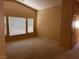 A bright living room with neutral carpet, high ceiling, and multiple windows at 8688 Tomnitz Ave # 101, Las Vegas, NV 89178