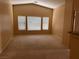 A bright living room with neutral carpet, high ceiling, and multiple windows at 8688 Tomnitz Ave # 101, Las Vegas, NV 89178