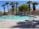 Community pool featuring clear blue water, a metal fence and palm trees at 8688 Tomnitz Ave # 101, Las Vegas, NV 89178
