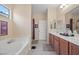 Bright bathroom featuring double sinks, soaking tub, and separate shower at 9457 Alma Ridge Ave, Las Vegas, NV 89178
