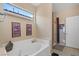 Bright bathroom features tub, shower, and a large window for ample light at 9457 Alma Ridge Ave, Las Vegas, NV 89178
